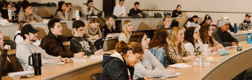 Students sitting in a large lecture hall.